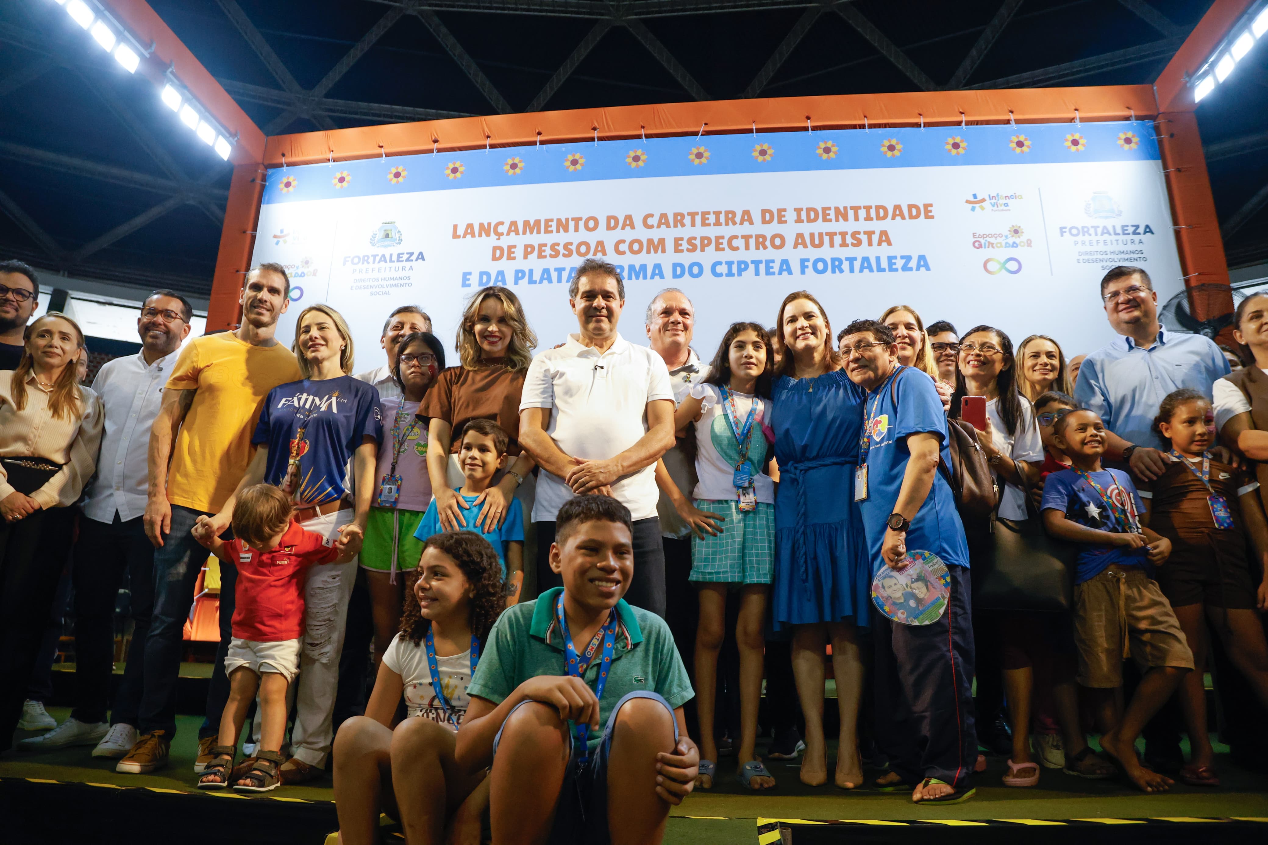 grupo de pessoas posa para a foto no palco montado na quadra do ginásio paulo sarasate